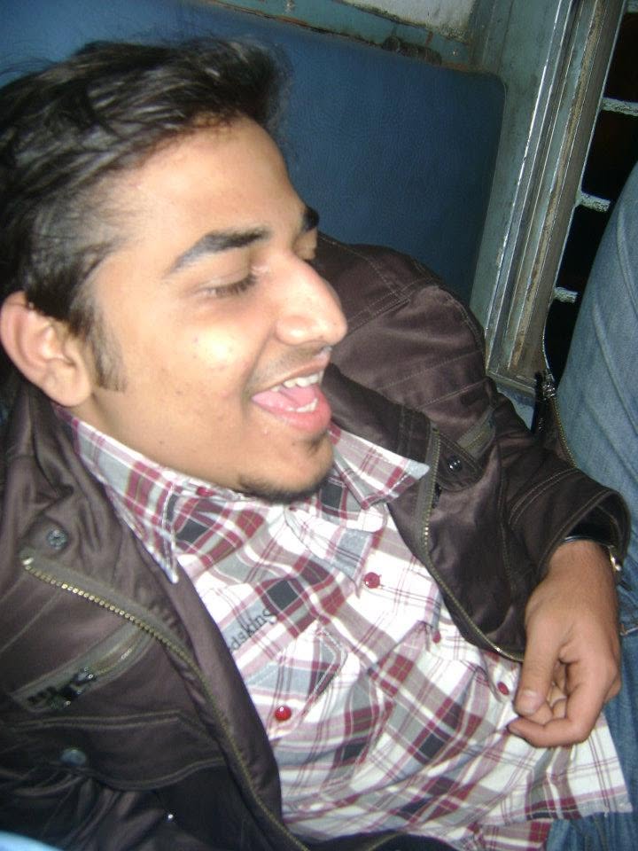 Mufaddal in 2010, laughing, in a plaid shirt and brown leather jacket
